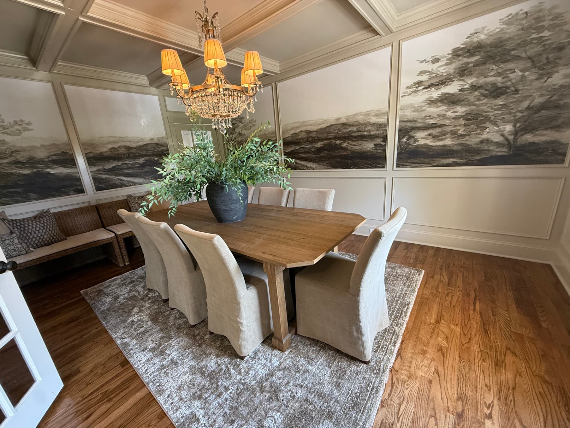 Dining room with mural panels, oak table and slipcovered chairs